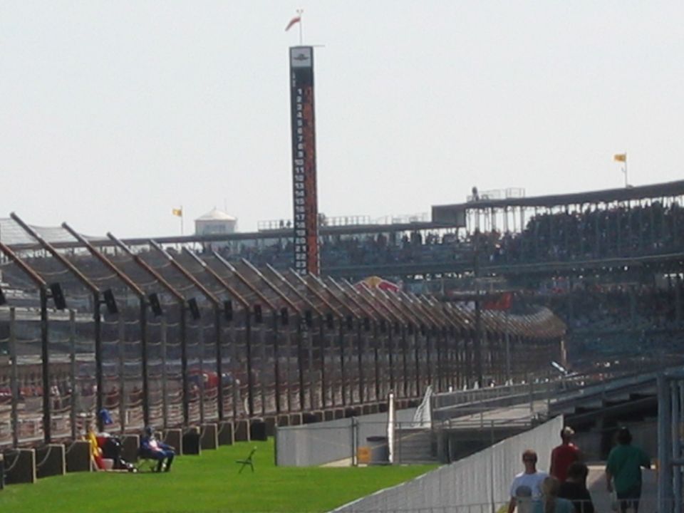 Racetrack scoring pylon, catch fence and crowded grandstands