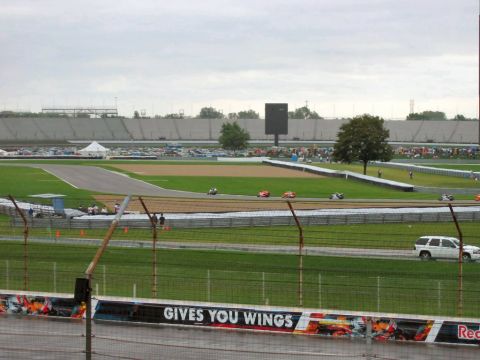 1985 Ford LTD Crown Victoria - Photograph of a road racing circuit infield and grandstands; not a technical document.