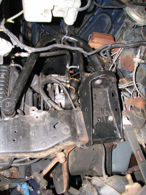 1984 Ford Bronco - This is a close-up, low-angle shot of the engine bay of a vintage Ford Bronco, showing various mechanical components and the vehicle's fram…