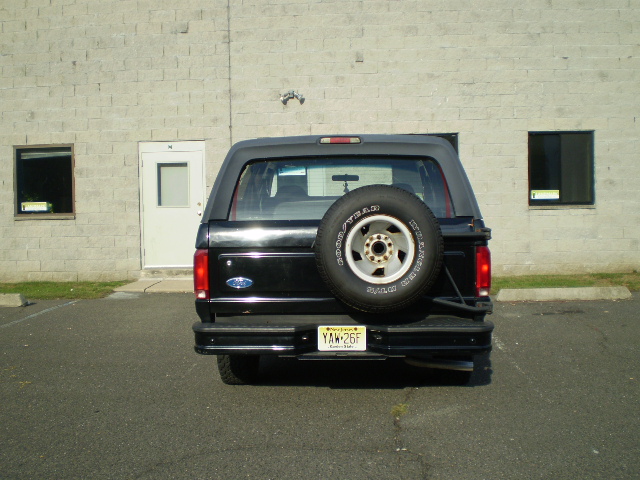 Rear view of a black 1996 Ford Bronco with a spare tire on the tailgate.