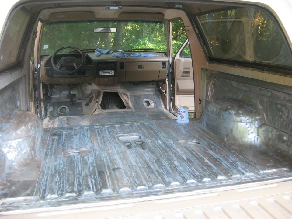 Gutted interior of an SUV with stripped floor, dash and rear cargo area