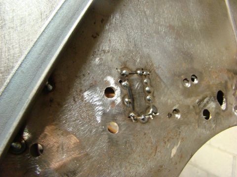 1948 Jeep Wrangler - Metal panel repair with welded patch and multiple drilled holes.