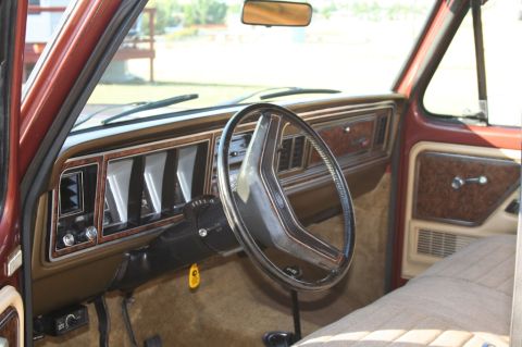 1979 Ford Bronco - The interior of a 1979 Ford Bronco features woodgrain accents on the dashboard and door panels.