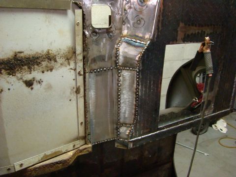 1948 Jeep Wrangler - Metal body panel undergoing welding repair, showing patched sections and rivets.