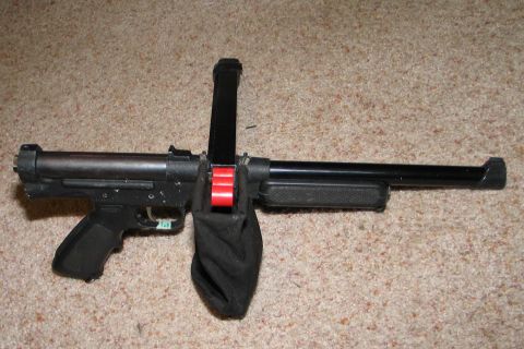 1994 Ford Bronco - A black firearm with an attached magazine and a black shell catcher is displayed on a carpeted surface.