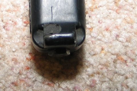 1994 Ford Bronco - Black plastic part with metal pin, resting on carpeted surface.