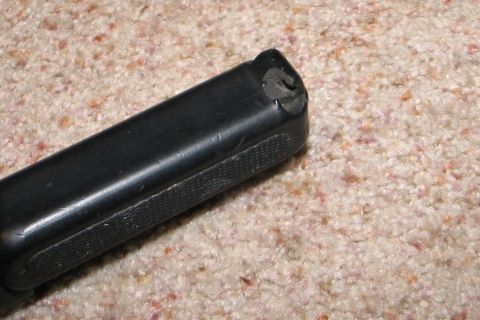 1994 Ford Bronco - A close-up view of a black component with a textured grip area, placed on a carpeted surface.