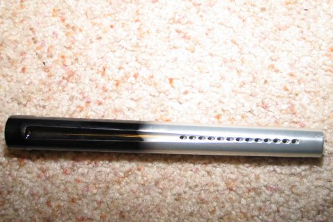 1994 Ford Bronco - A paintball barrel, black on one end and silver with air holes on the other, lies on a carpeted surface.