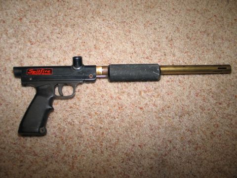 1994 Ford Bronco - A black Spitfire paintball gun with a brass barrel is shown on a carpeted surface.