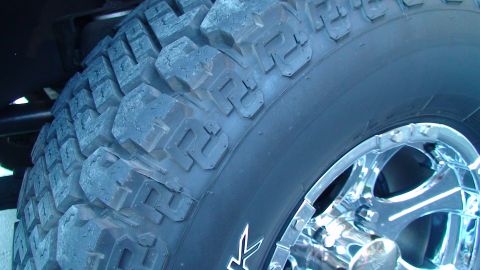 1979 Ford Bronco - Aggressive off-road tire mounted on a polished chrome wheel.
