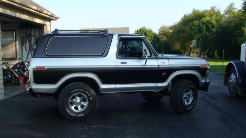 1979 Ford Bronco - A two-tone black and silver Ford Bronco is parked outside a garage.