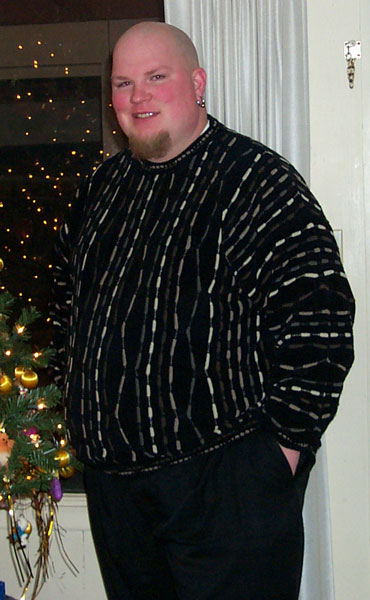 1996 Ford Bronco - Man in sweater and pants with Christmas lights and tree in background.