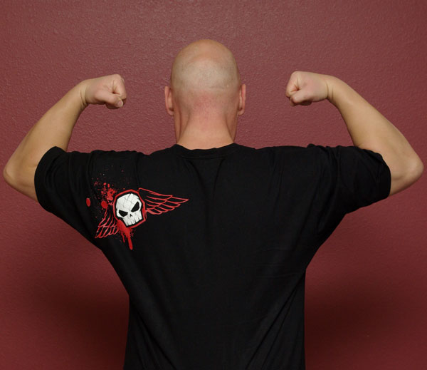 Man from behind flexing arms, wearing black t-shirt with winged skull print