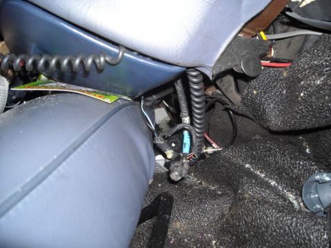 1996 Ford Crown Victoria - Close-up of the interior of a vehicle, showing coiled wires and exposed electrical components near the seat base.