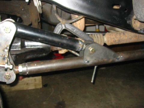1995 Ford Bronco - Undercarriage view of modified suspension parts, including tie rods and a drag link.
