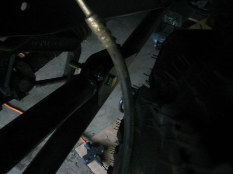 1995 Ford Bronco - Underside view of vehicle suspension components, showing a brake line and mounting bracket.