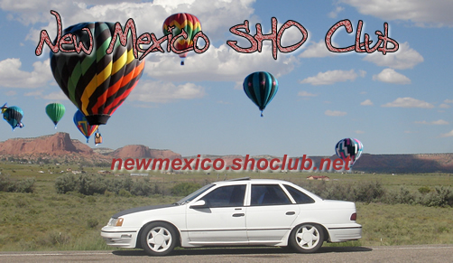 New Mexico SHO Club banner with a white Ford Taurus sedan and desert hot air balloons