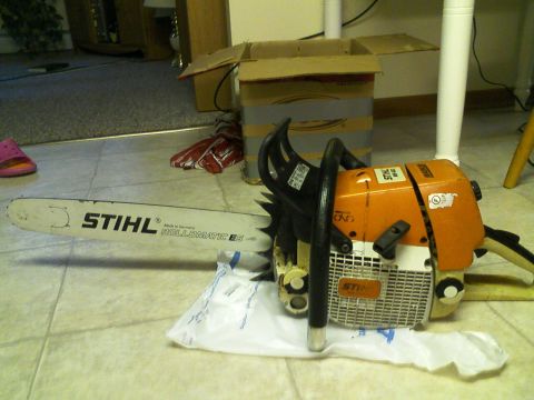 2000 Chevrolet Tahoe - A Stihl chainsaw rests on a protective sheet on the floor, with a cardboard box and other items in the background.