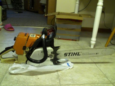 2000 Chevrolet Tahoe - A Stihl chainsaw is shown on a tiled floor, with a cardboard box and furniture in the background.