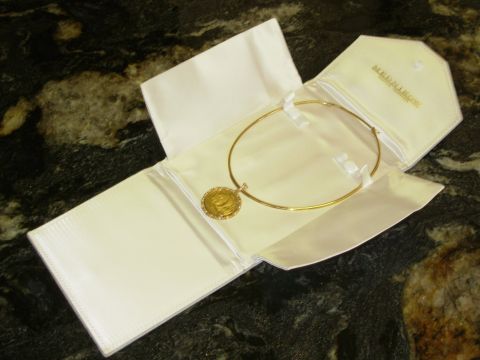 2004 Land Rover Land Rover - A gold necklace with a coin pendant is displayed in a white jewelry box.