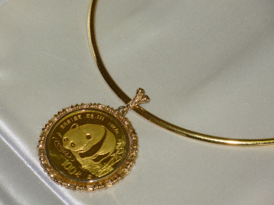 Gold panda coin pendant on a gold necklace