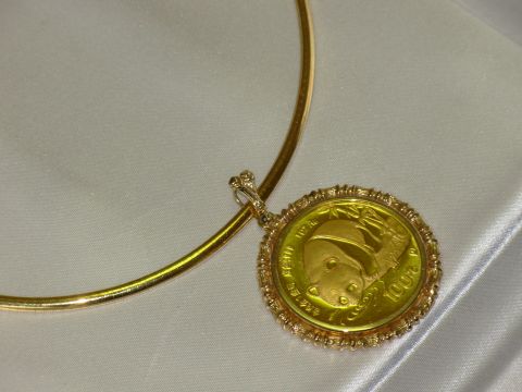 2004 Land Rover Land Rover - A gold panda coin pendant is shown, the year 2004 on its surface.