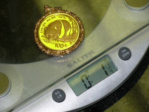 2004 Land Rover Land Rover - A gold panda coin pendant is weighed on a digital scale.