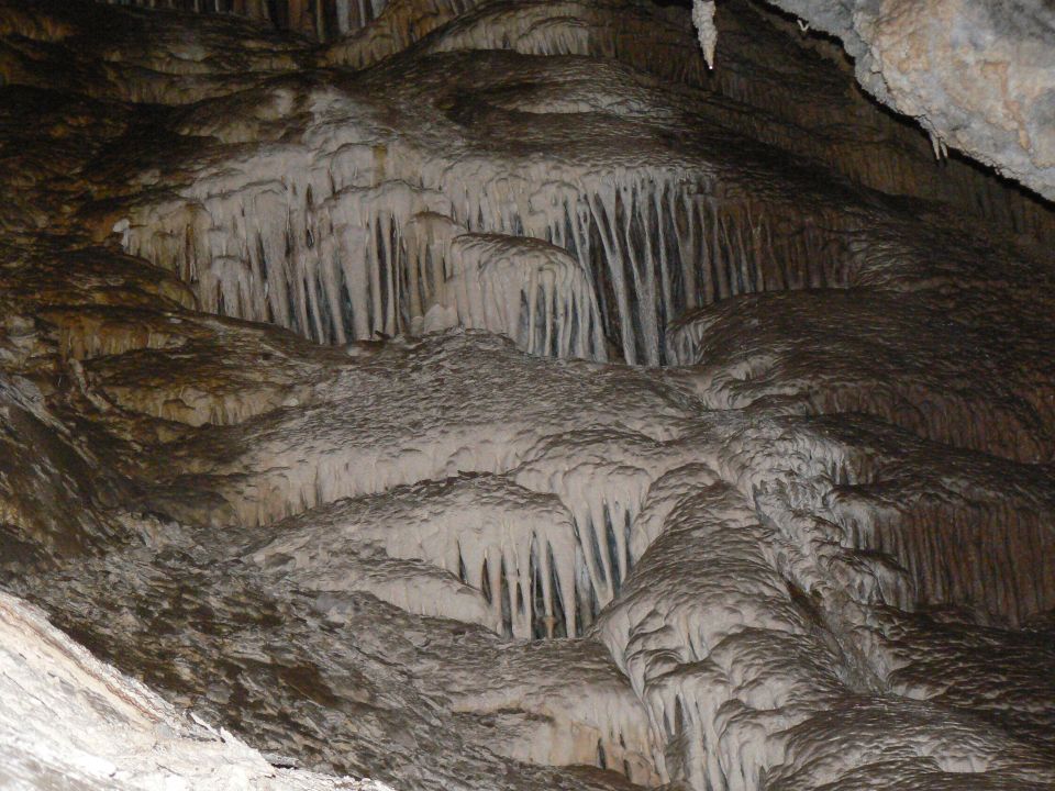 Stalactites and flowstone formations inside a cave