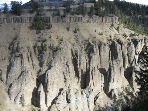 2006 Ford E350 - Geological formations create a dramatic cliff face with a line of vertical rock pillars at the top.