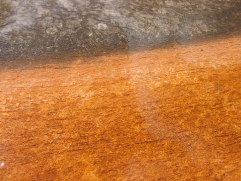 2006 Ford E350 - Close-up of mineral deposits on a wet surface, showing distinct orange and gray coloration.