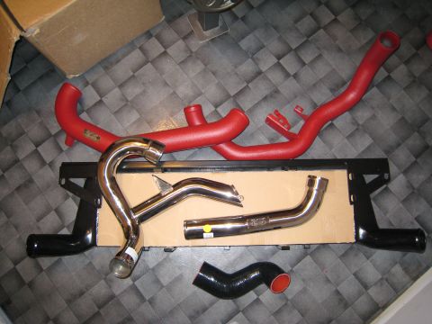 2007 Subaru Impreza - Various automotive intercooler piping components are laid out on a dark checkered floor.