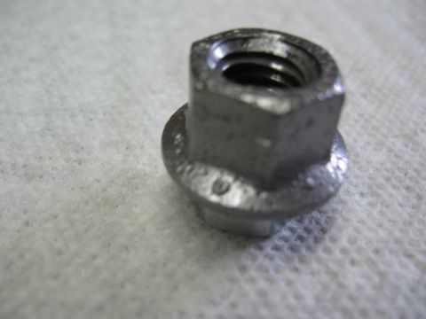 1968 Shelby GT500 - A single metal nut with a flange is shown in detail against a textured background.