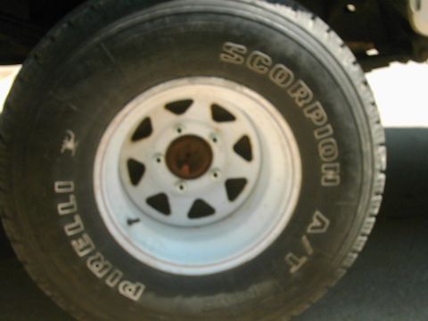 1987 Ford Bronco - Close-up of a Pirelli Scorpion A/T tire mounted on a white wheel.