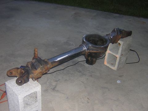 1993 Ford Bronco - A front axle assembly, likely from a truck or SUV, is shown disassembled and resting on concrete blocks.