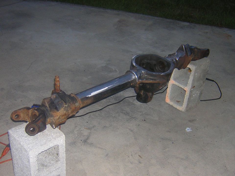 Front axle assembly resting on concrete blocks