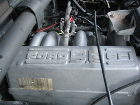 1995 Ford Bronco - Close-up of the engine intake manifold, identified as a 5.0 HO, with a VIN sticker visible.
