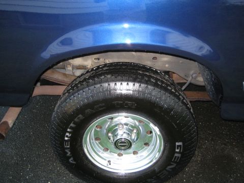 1995 Ford Bronco - Close-up of the rear wheel well and tire on a blue vehicle.