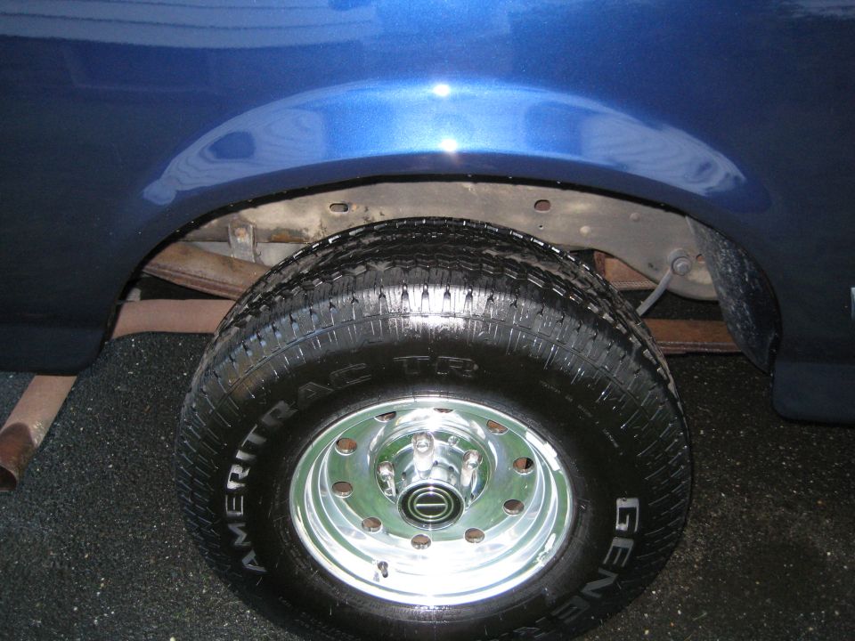 Chrome wheel with Ameritrac tire under blue truck fender