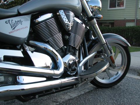2006 Victory Kingpin - Close-up view of a silver Victory motorcycle's engine, chrome exhaust pipes, and front wheel.