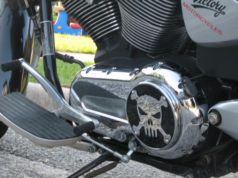 2006 Victory Kingpin - Close-up of a motorcycle engine a chrome cover with a skull and crossbones emblem and 'Victory Motorcycles' branding.