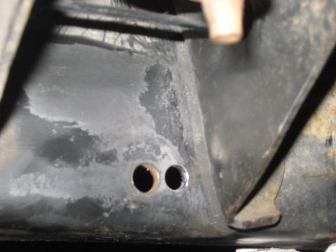 1991 Ford Bronco - Close-up view of a vehicle's frame, showing two circular holes.