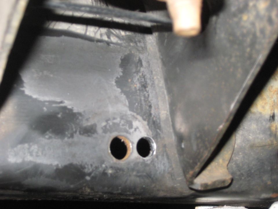 Close-up of vehicle frame with two holes