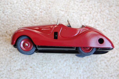 1968 Chrysler Town & Country - A red toy car with a vintage design sits on a textured surface.
