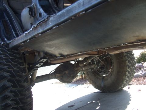 1994 Jeep Cherokee - This photo shows the undercarriage of a vehicle, focusing on newly installed metal plating on the rocker panel and visible suspension parts.