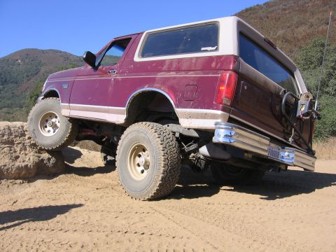 1989 Ford Bronco - This 1989 Ford Bronco navigates a rocky trail with its front tire elevated.