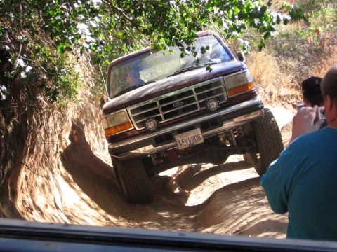 1989 Ford Bronco - Ford Bronco tackling a challenging off-road trail with steep inclines and tight turns.