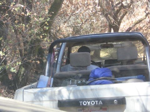 1989 Ford Bronco - Interior view of a white Toyota SUV, possibly off-roading, with occupants and supplies inside.