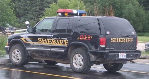 1991 Ford Crown Victoria - Custer County Sheriff's Chevrolet Blazer SUV parked on a wet surface.