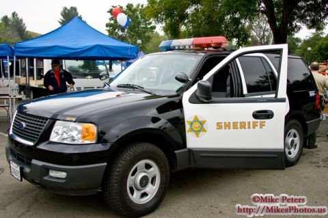 1991 Ford Crown Victoria - A Ford Expedition SUV is marked as a sheriff's vehicle, with its driver's side door open.