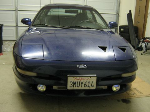 1995 Ford Probe - Front view of a blue 1995 Ford Probe with its pop-up headlights down, parked indoors.